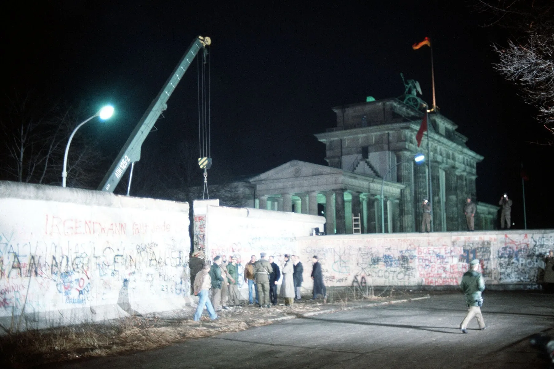 Berlin, décembre 1989 : une grue enlève une section du Mur à la porte de Brandebourg — la liste des murs se change en plan d’une porte (photo : U.S. Air Force, SSgt F. Lee Corkran).
